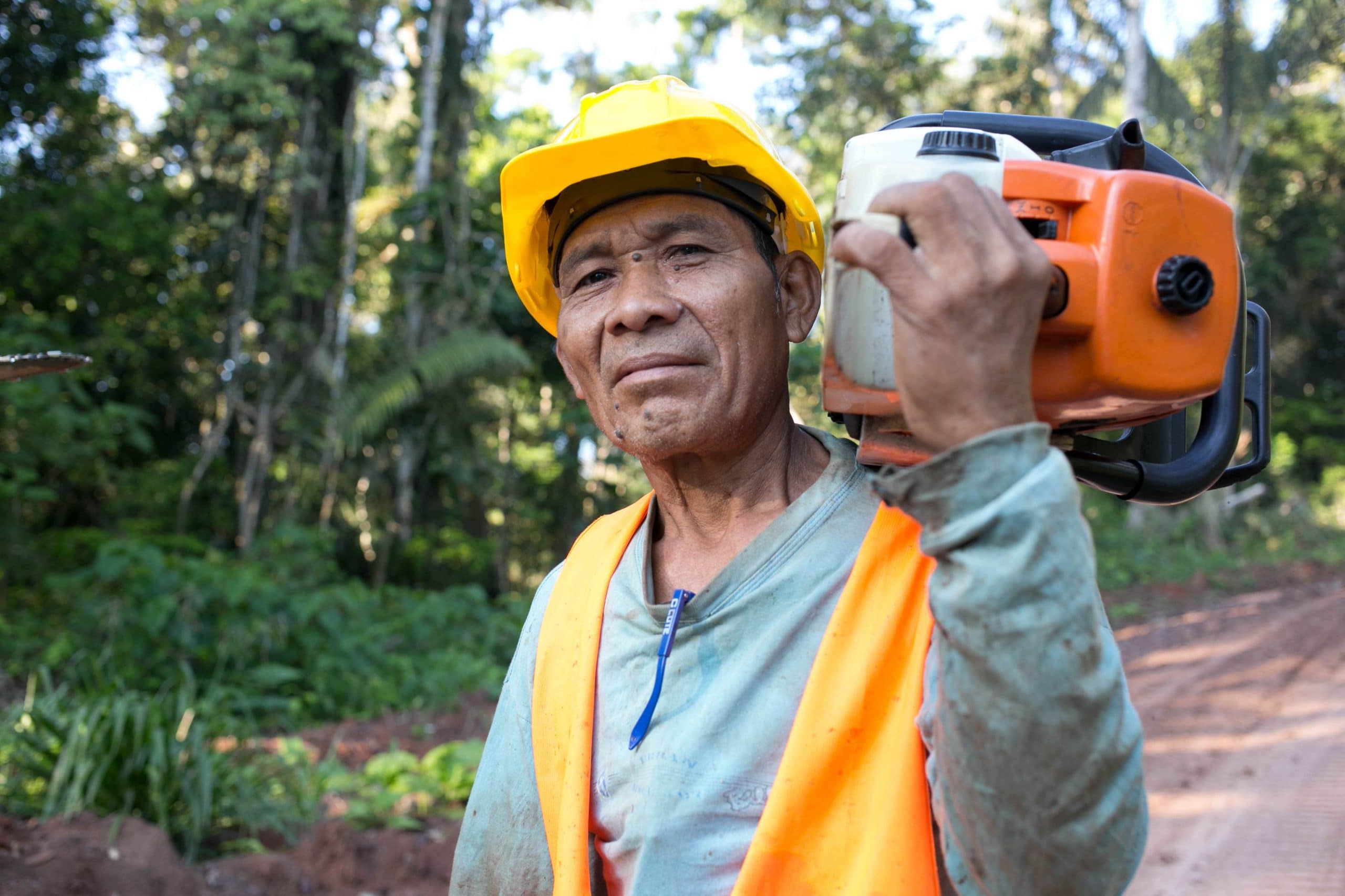 Lumberjack carrying a chainsaw on his shoulder